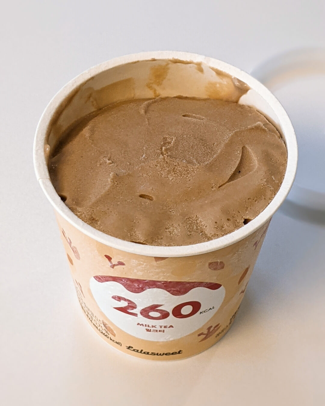 연한 브라운색의 라라스윗 밀크티 아이스크림 내용물이 보이는 장면