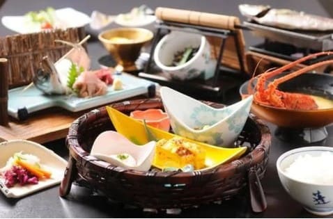 식탁위에 일본 접시가 놓여져 있고 작은 음식들이 담겨져 있다.