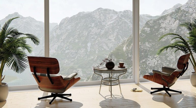 산이 보이는 거실에 의자가 있는 모습