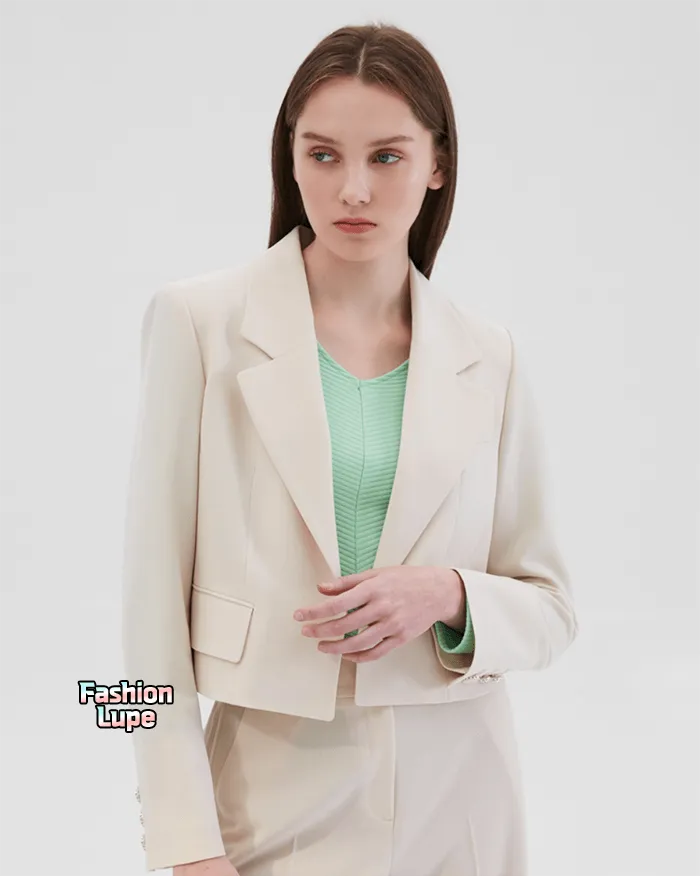 라이트 베이지 컬러 자켓과 팬츠를 입고 있는 모델의 상반신 컷