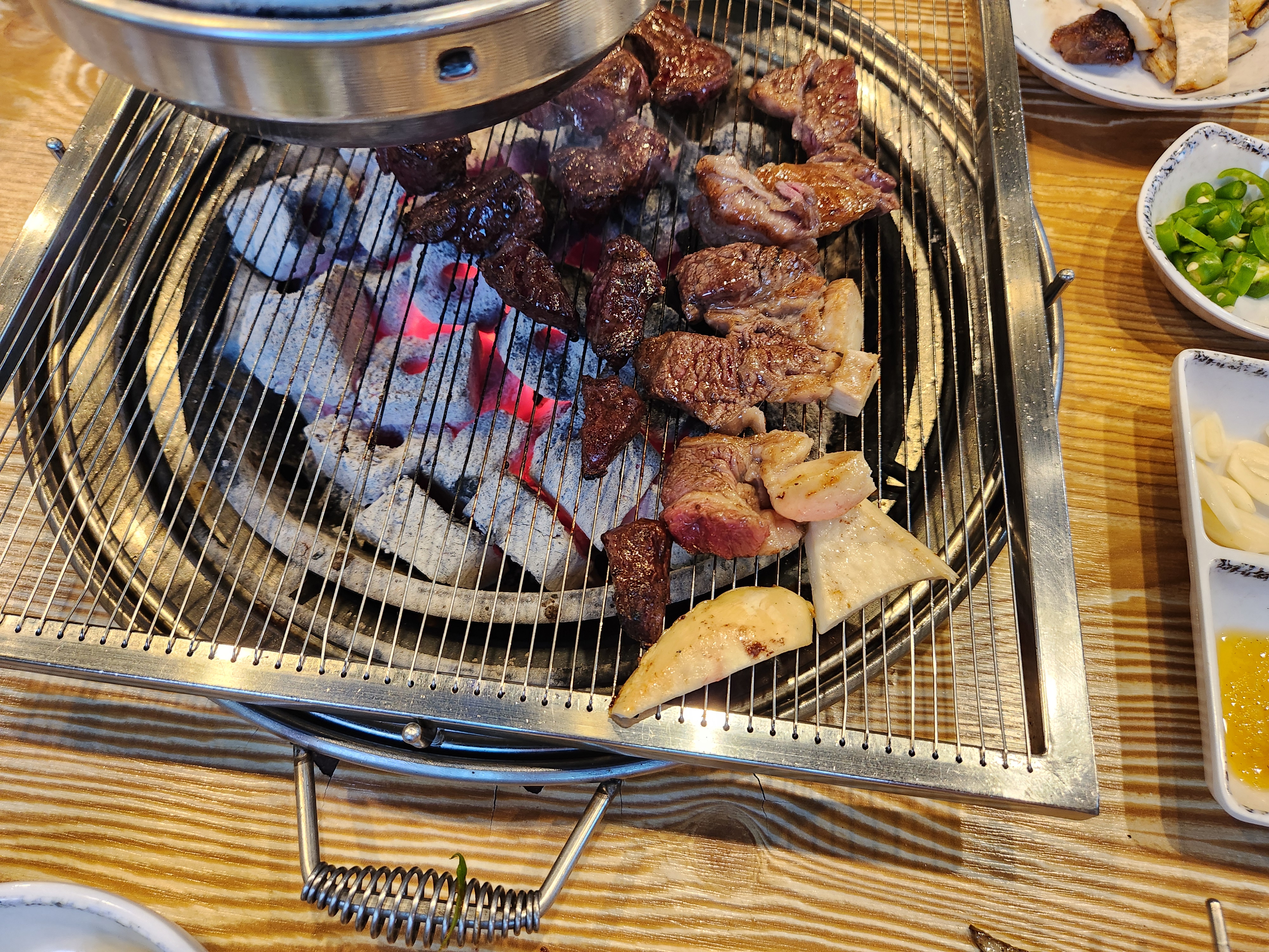 숯불 위에서 고기를 굽고 있다.
