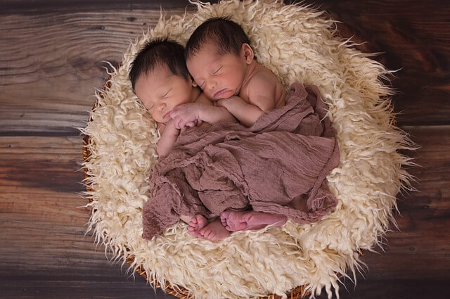 쌍둥이로 보이는 아기 2명이 서로 기대어 자는 모습
