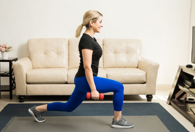 a woman who works out in front of the couch at home