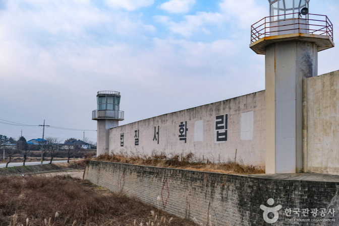 높은 교도소세트건물 담벼락에 법질서확립이란 글씨가 써있는 건물사진