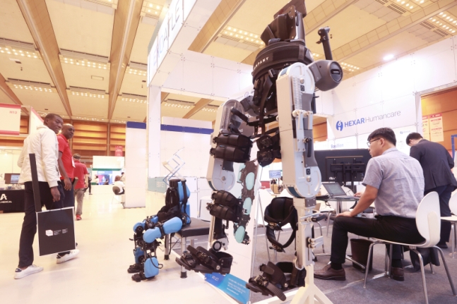 2022년 9월 서울 강남구 코엑스에서 열린 2023 국제 병원 및 의료기기 산업박람회에서 참관객들이 지면 보행 웨어러블 재활 로봇을 살펴보고 있다.