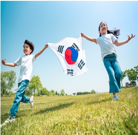 아이들이 활기차게 국기들고 즐거워하는 사진