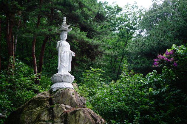 바위 위에 연꽃 모양의 돌받침대 위 부처&#44; 서 있는 전신 상&#44; 이중 갓&#44;