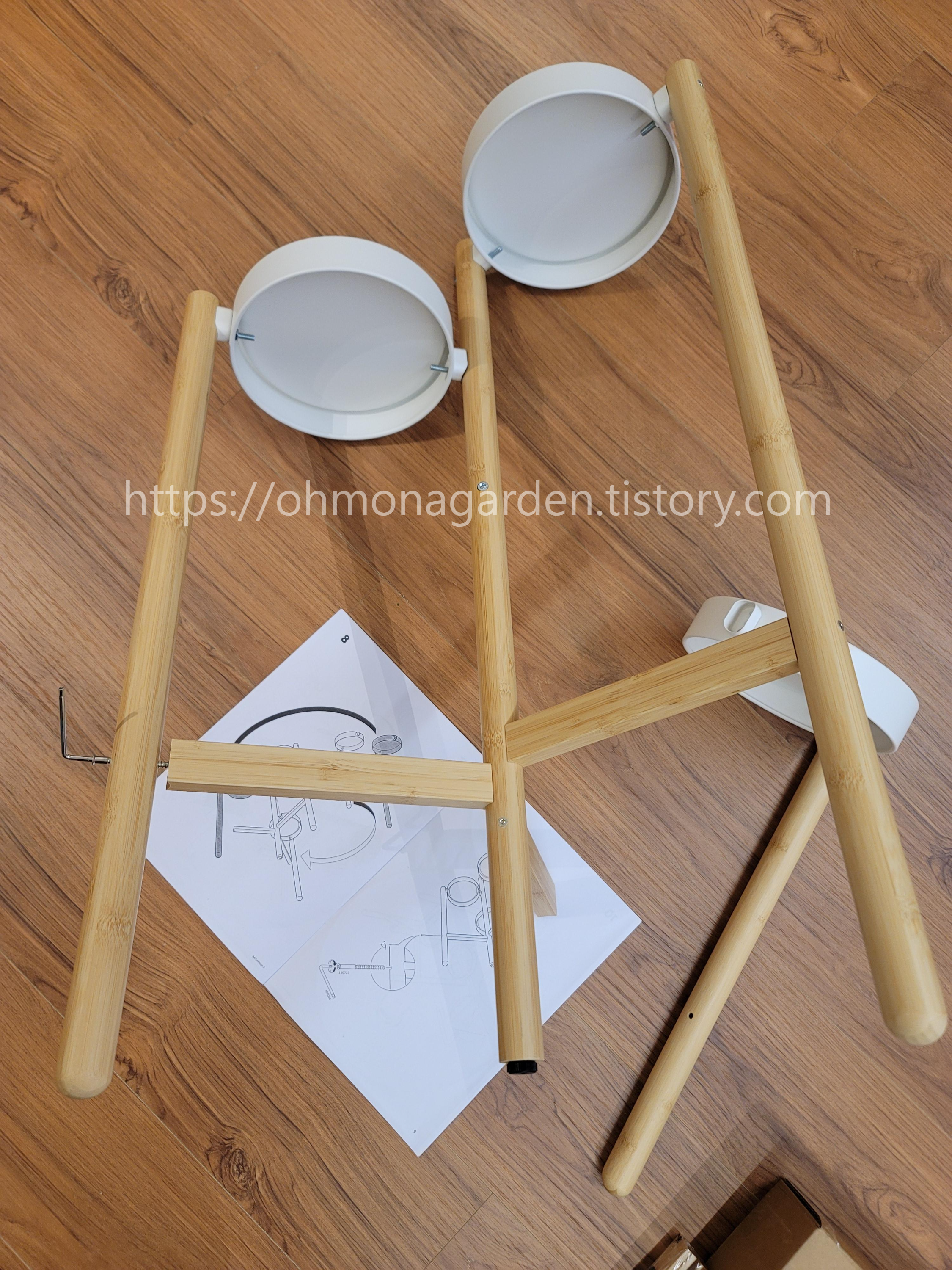 Attach the central pole of the IKEA SATSUMAS to the three legs with attached trays using screws.