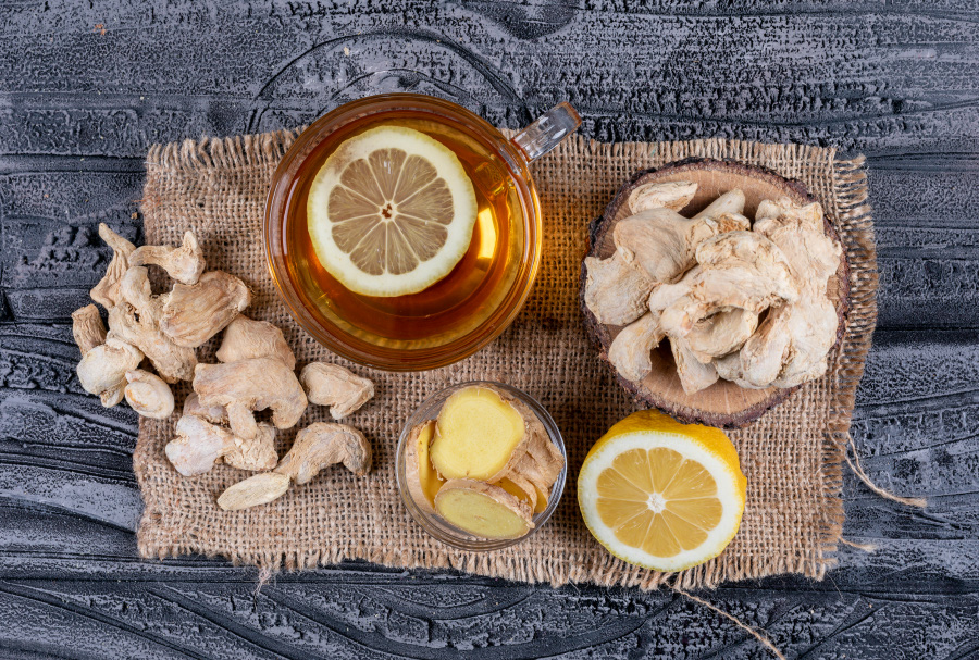 top-view-ginger-with-tea-lemon-ginger-slices-sack-cloth-dark-wooden-background-horizontal-900