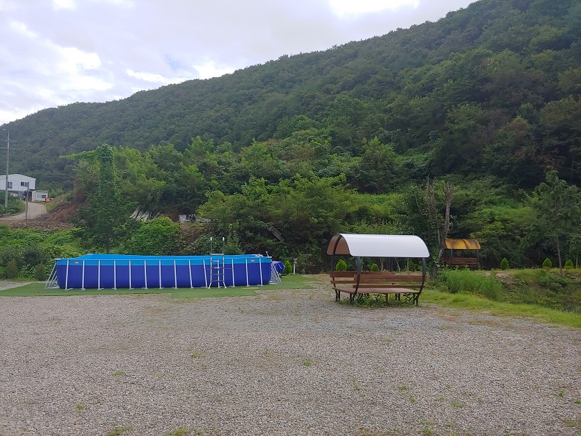 산-아래-파란색-수영장과-지붕있는-벤치