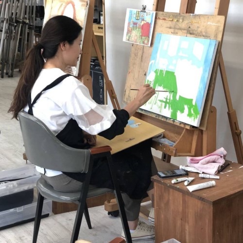 그녀가 의자에 앉아 그림을 그리고 있는 사진