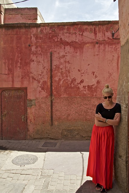 선글라스를 쓴 여성이 벽에 기대 서있는 모습