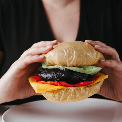 비닐로 햄버거를 만들어서 먹는듯한 모습을 보이는 사진
