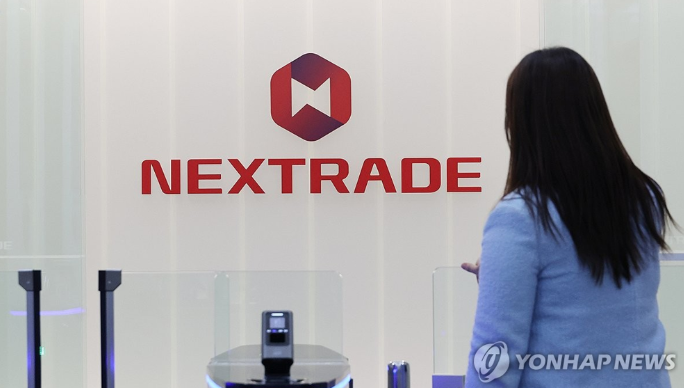 넥스트레이드(NXT) 로고 앞에서 직원이 거래소 입구로 진입한다.