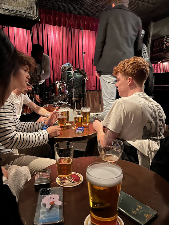 맥주가놓여있는테이블에둘러앉은젊은이들