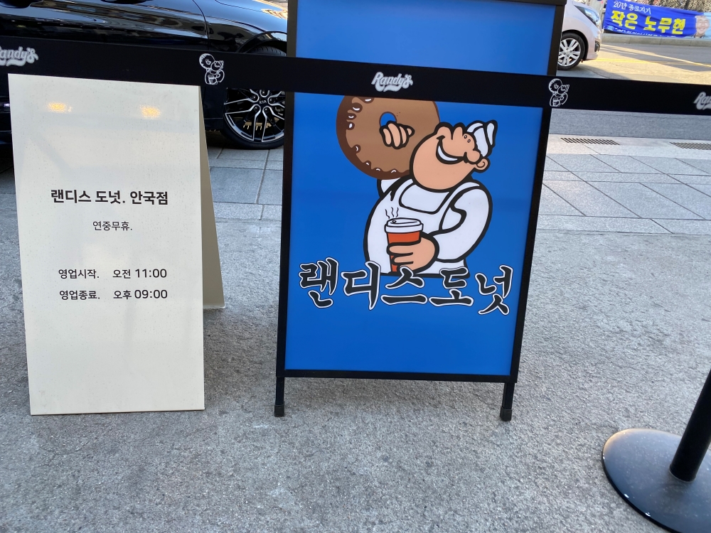 랜디스 도넛 안국점 영업시간이 적혀있는 입간판