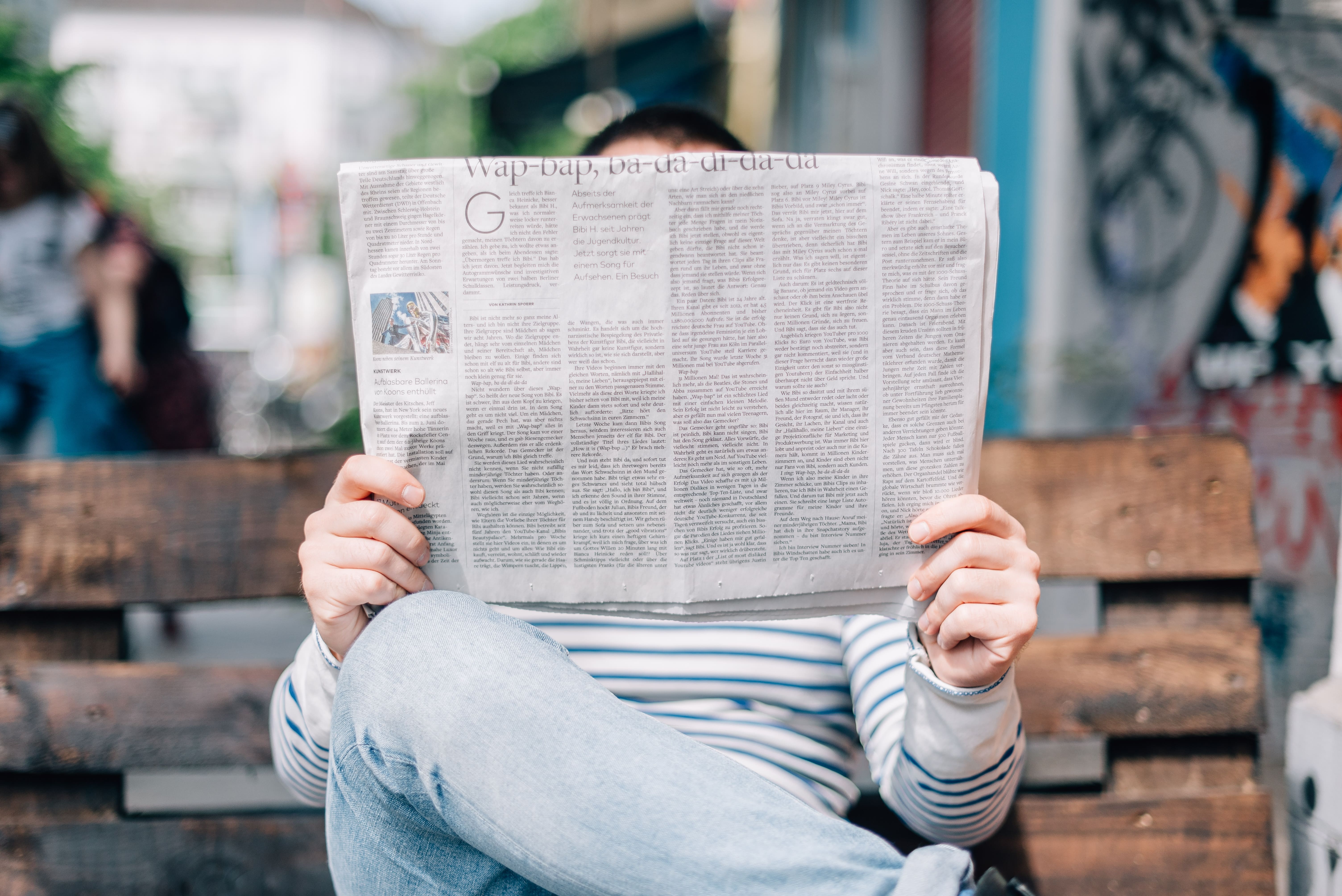 The other side of the person reading the newspaper