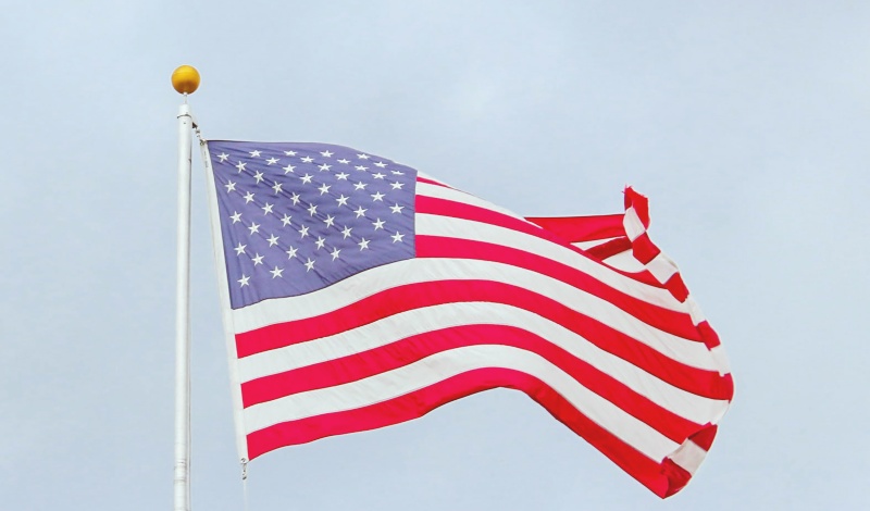 U.S. flag waving in the sky, symbolizing American immigration and visa opportunity for international students