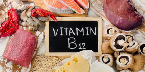 가운데 블랙보드에 Vitamin B12가 적혀있고&#44; 주위에 그와 관련된 음식들이 놓여져 있다