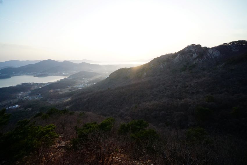 낙조봉 뒤에서 비치는 역광 햇살&#44; 왼쪽에 바다&#44; 섬&#44; 풍경&#44; 흐린 하늘&#44;