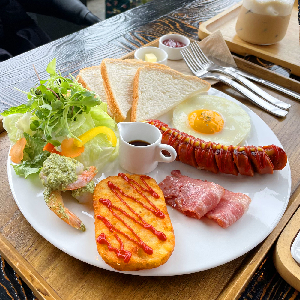 중앙에-식빵&#44;-샐러드&#44;-해시브라운&#44;-베이컨&#44;-소시지&#44;-달걀프라이로-이루어진-브런치-메뉴가-있고&#44;-뒤에-딸기잼&#44;-버터&#44;-포크&#44;-칼이-놓여-있습니다.(2)