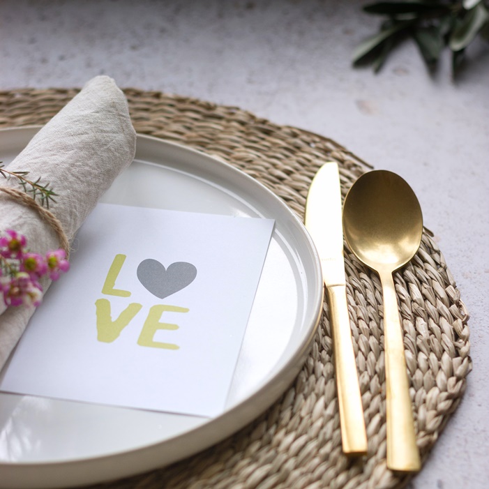 love라고 써있는 종이가 놓여있는 하얀색 철재 쟁반과 금색 스푼과 나이프