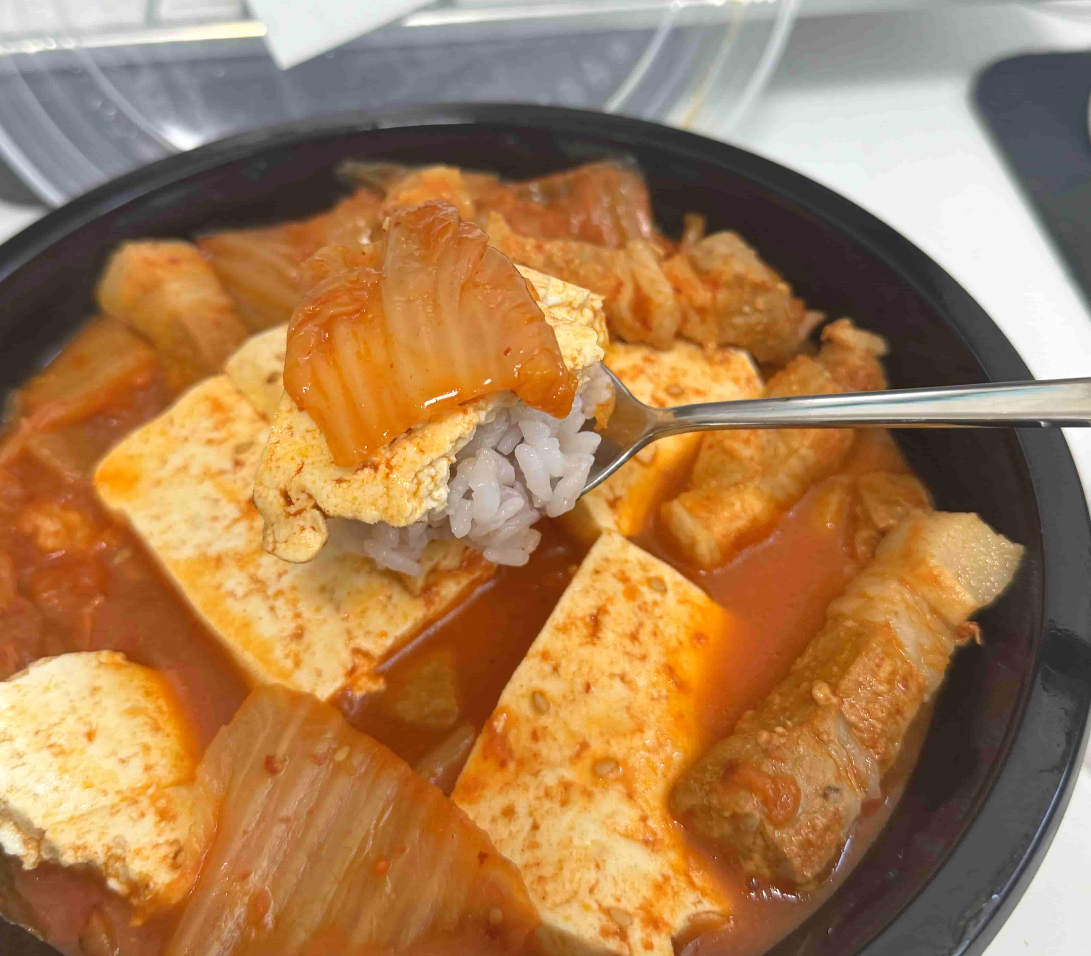 김치찜의 김치와 두부를 밥과 함께 먹는 사진