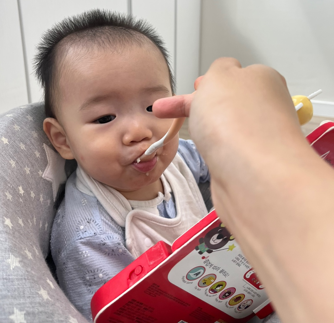 아기가 오트밀 이유식을 받아 먹는 사진2