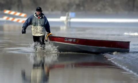 ared Bakko hauls a boat down a flooded road after taking supplies to his grandmother as the Red River flood waters began to recede just south of Moorhead&#44; Minnesota&#44; USA&#44; 28 March&#44; 2009. EPA/CRAIG LASSIG &amp;nbsp;Photograph: Craig Lassig/EPA