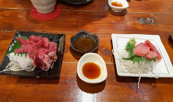 접시 2개 위에 사시미 같은 붉은색의 음식이 올려져 있다.