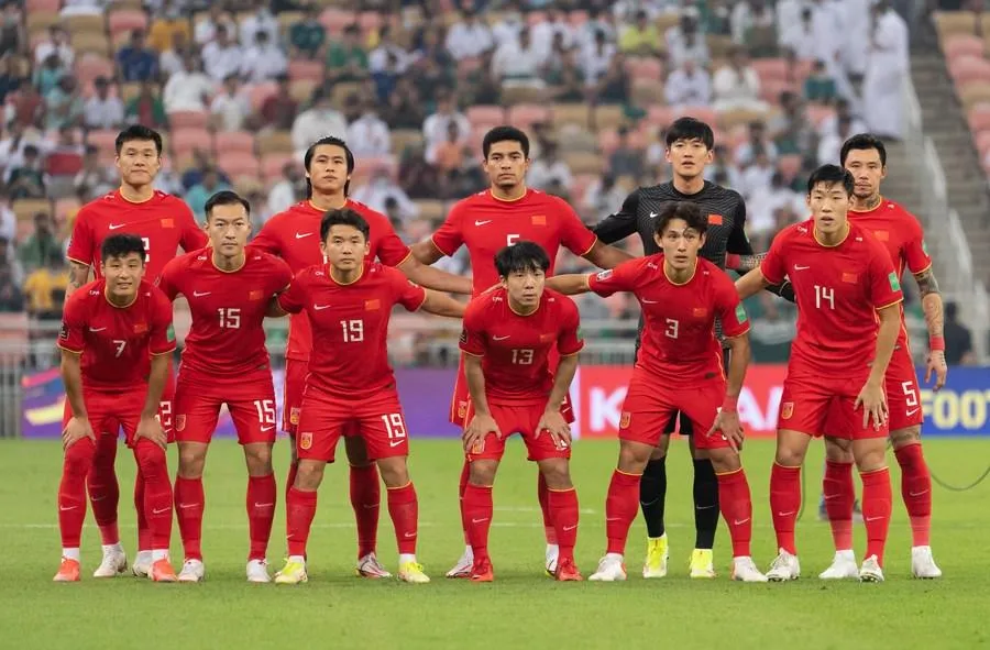 중국 선수들이 축구 경기장에서 단체로 사진 찍고 있는 모습입니다.