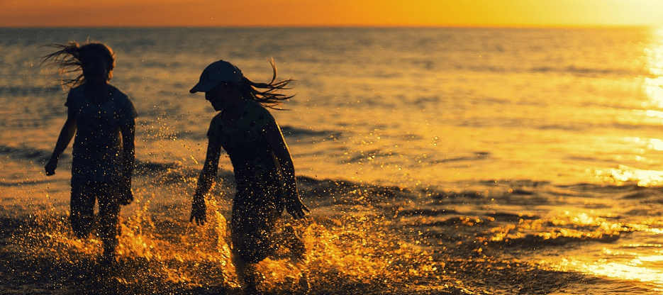 두명의 소녀가 바다에서 물놀이를 하고 있다