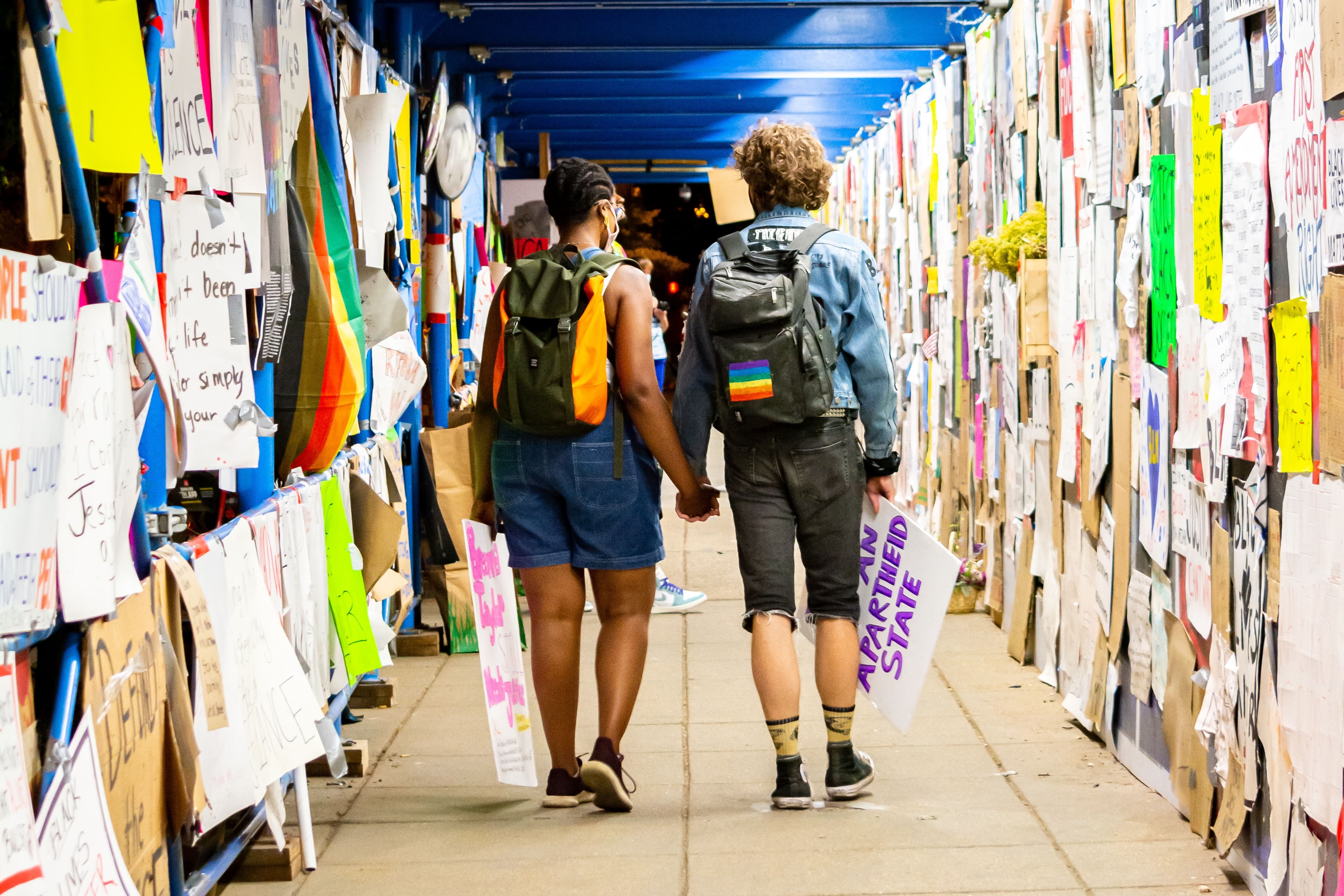 People passing by advertisements on the wall