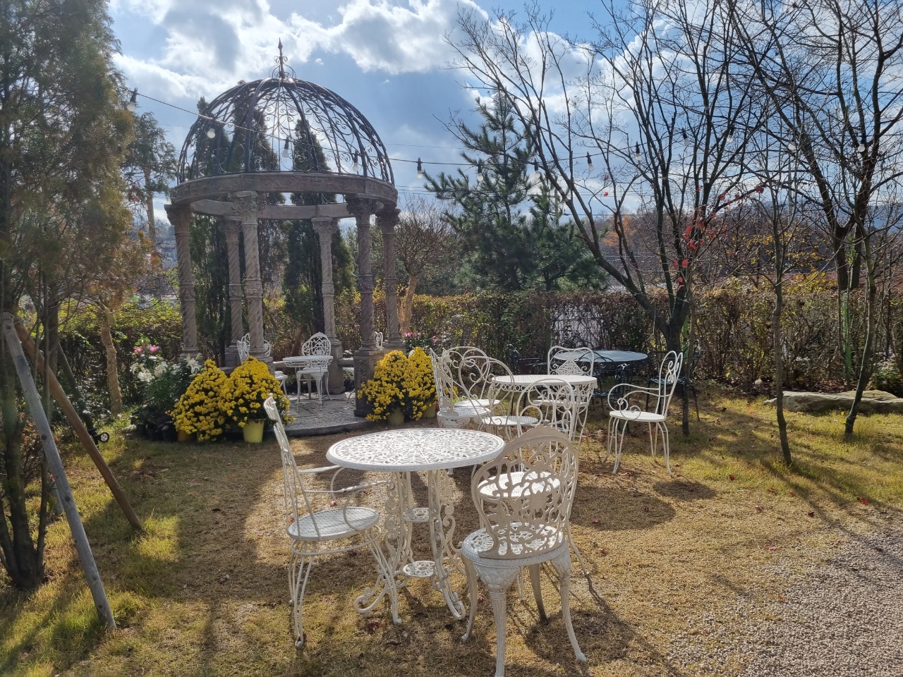 궁전같은-곳-안에-테이블과-의자들-주변-꽃들과-나무들