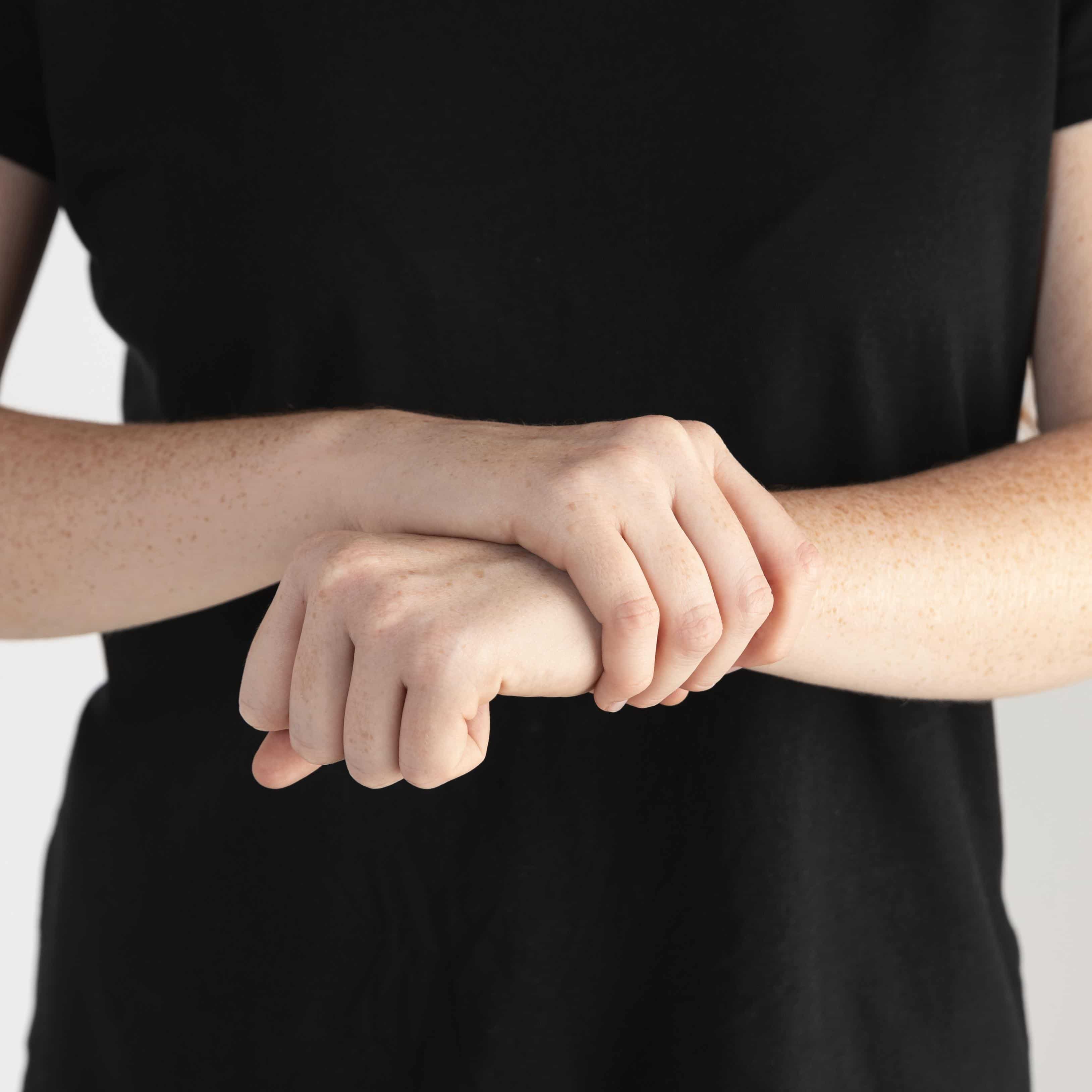 손목 통증을 느끼는 사람이 손목을 부여 잡고 있는 사진