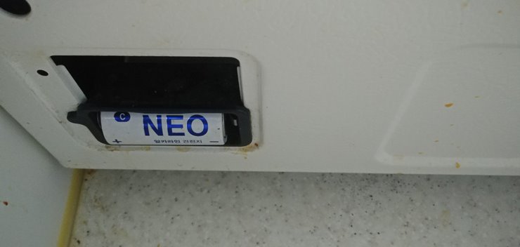 흰색 가스레인지 뒷면의 꽂혀있는 NEO D형 배터리