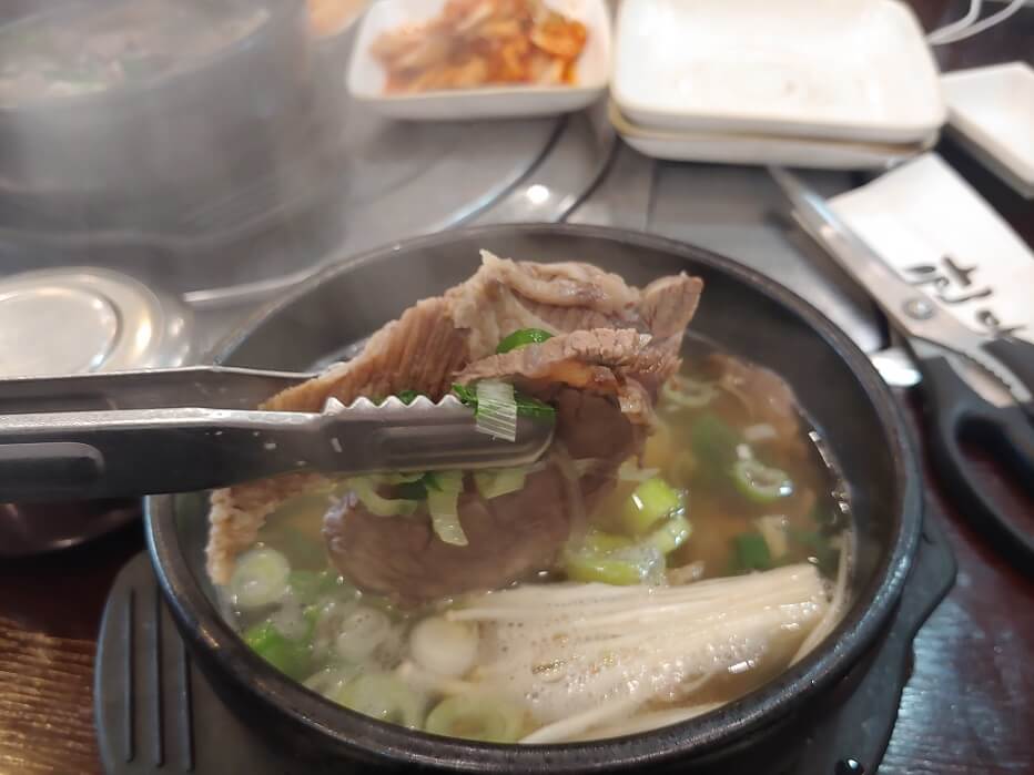 뚝배기안-고기를-집게로-들어올린-사진