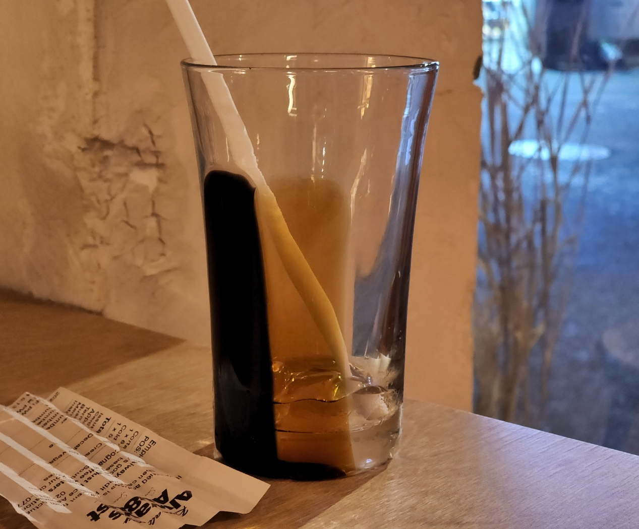 책상위에 올려져 있는 빈 아이스 커피잔과 아코디언 접기가 되어있는 영수증