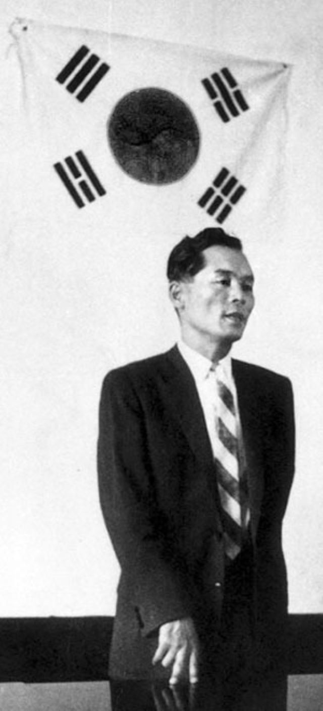 대산 신용호 회장이 젊은시절 태극기 앞에 서 있다.