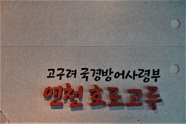 홍보관 안내문&#44; 회색 바탕에 붉은 글씨&#44; 연천 호로고루&#44; 검은 글씨로 고구려국경방어사령부&#44;