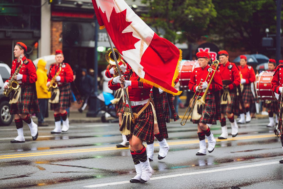 캐나다 국기를 들고 퍼레이드 하는 사진