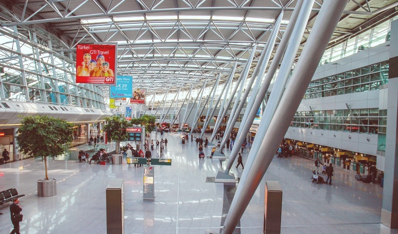 Modern airport terminal filled with travelers preparing for international flights