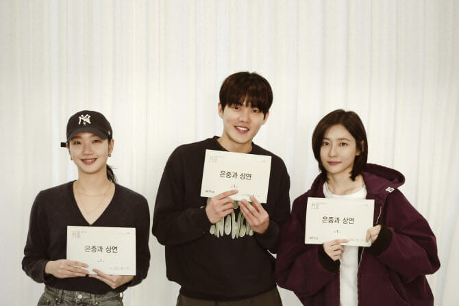 '은중과 상연' 드라마의 대본 리딩 현장. 주연 배우 김고은, 박지현, 김건우가 대본을 들고 나란히 서 있으며, 밝은 분위기 속에서도 미묘한 긴장감이 느껴진다.