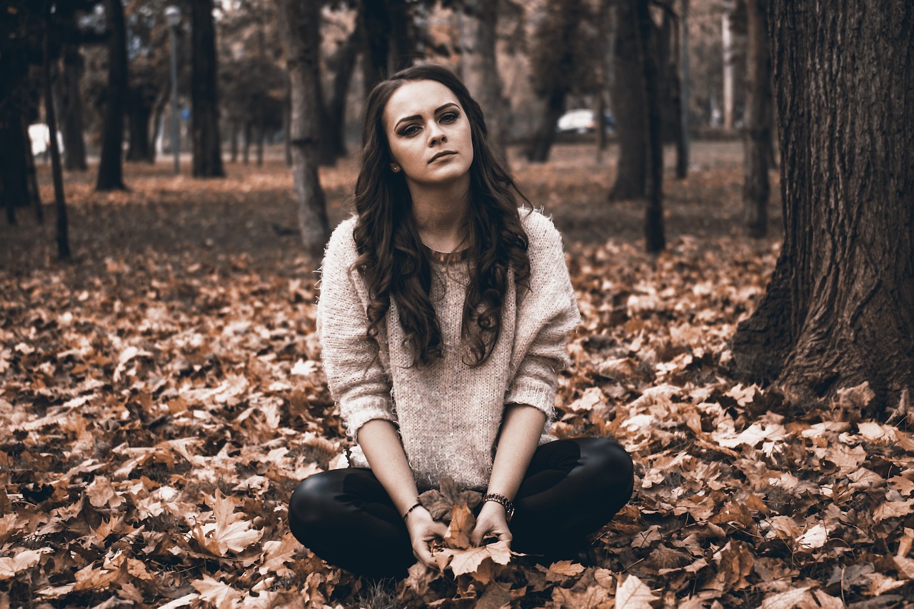 낙엽위에 앉아있는 여성의 모습