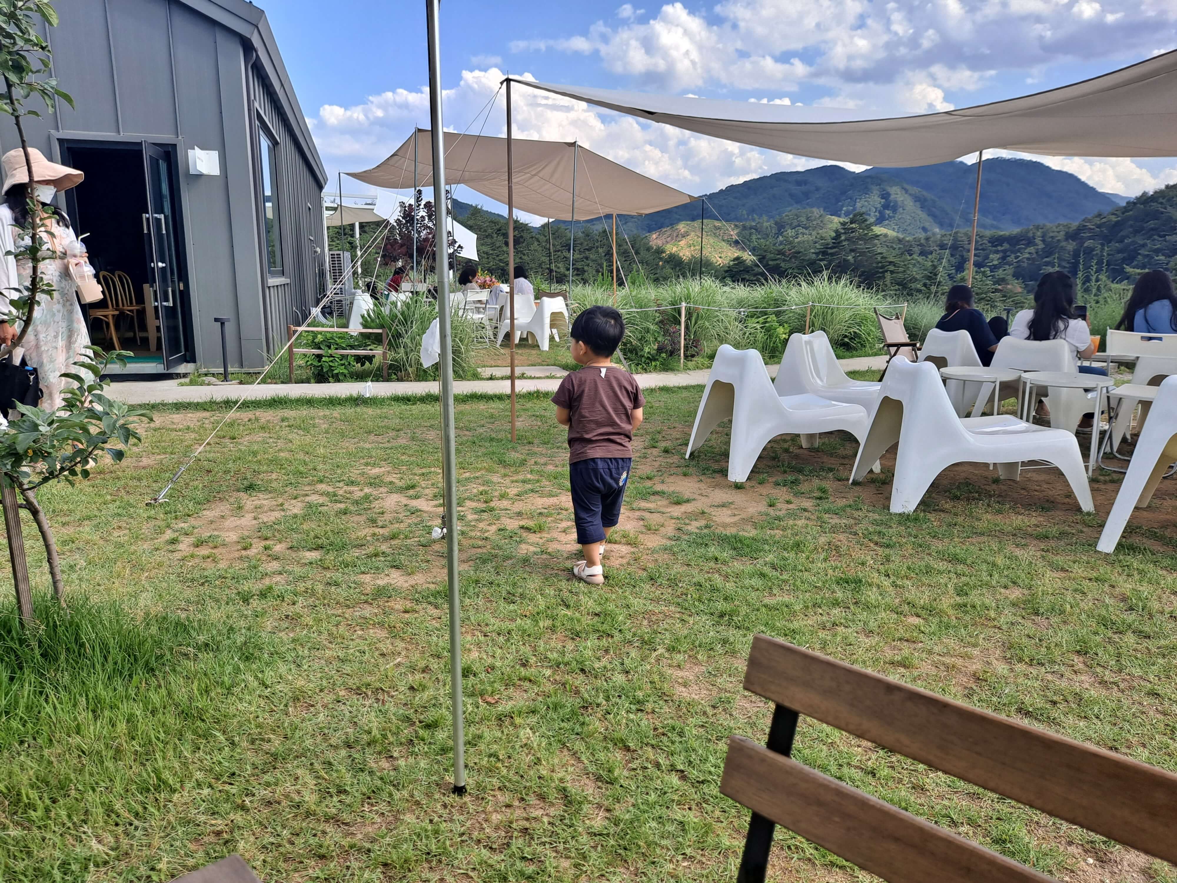 강원도 양양 베이커리 카페 실외 잔디와 테이블이 공존하는 공간에서 활보하는 아이 모습 촬영 이미지