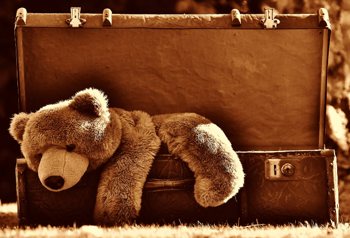 트렁크 가방에 걸쳐진 곰 인형 사진