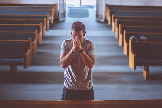 교회에서 간절히 기도하는 남자