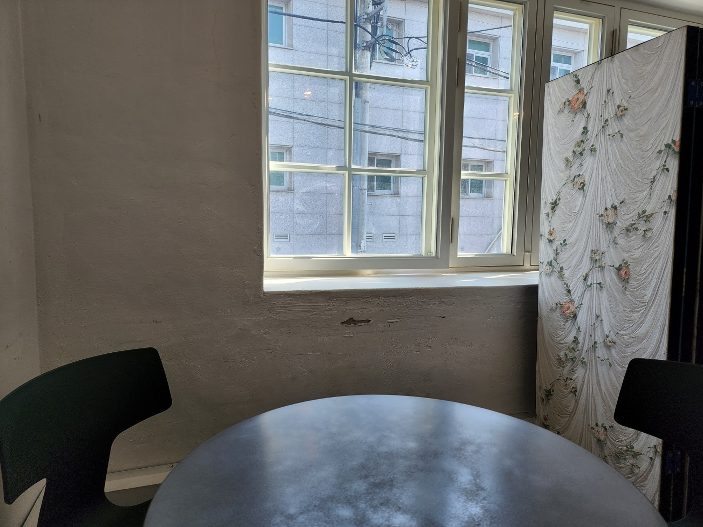 하얀 벽과 창문이 있는 가장 구석 자리 둥근 테이블