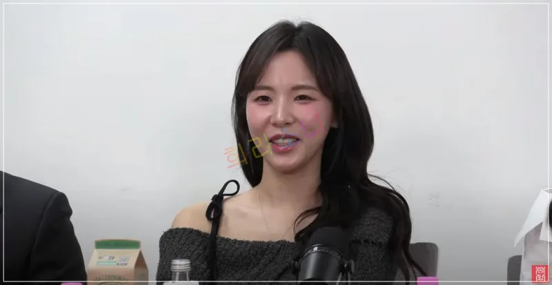 검은색 오프숄더 니트 상의를 입고 긴 웨이브 머리를 한 24기 순자가 마이크 앞에서 이야기하고 있다. 그녀는 옅은 미소를 지으며 화면을 응시하고 있으며&amp;#44; 테이블 위에는 물병과 종이컵이 놓여 있다. 화면 중앙에 &amp;quot;희리소니&amp;quot;라는 알록달록한 텍스트가 겹쳐져 있다. 