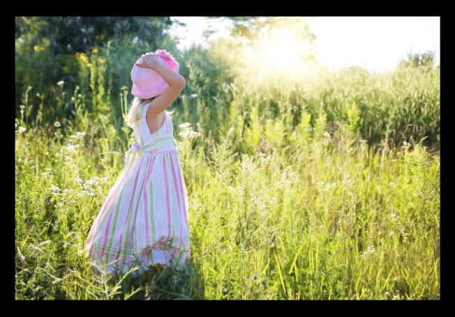여자 아이가 풀밭에서 놀고 있는 사진